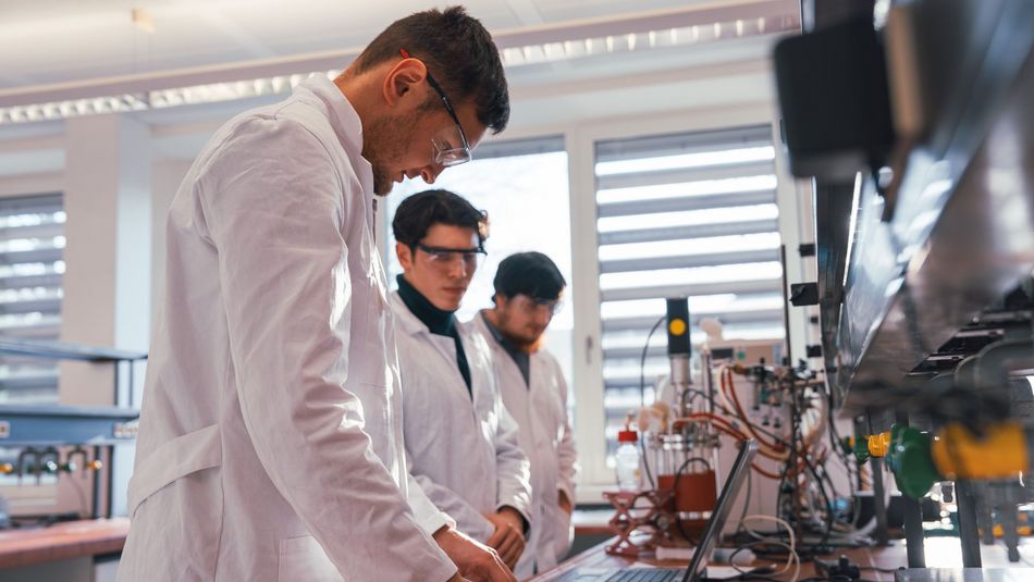 Studierende im Labor Bioprozesstechnik stehen vor der ssélbstgebauten Gärungsanlage